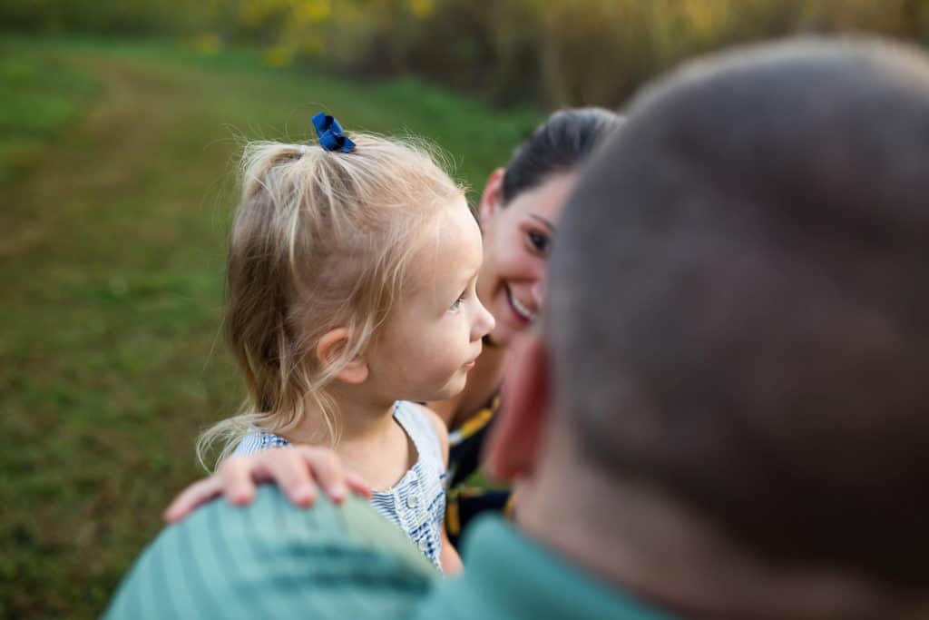 Mom, dad and daughter having fun in a field in kansas city