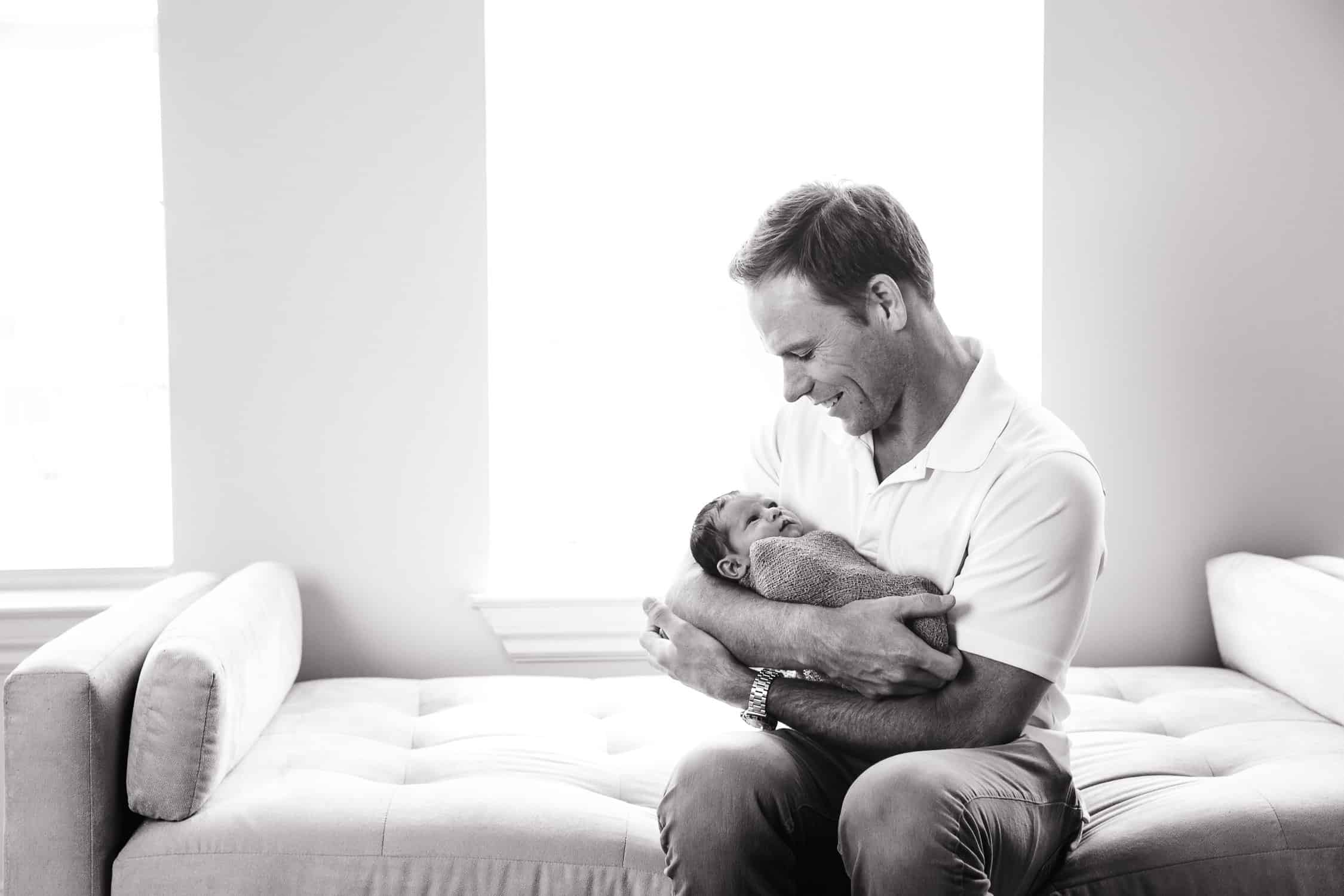 2 week old baby girl and dad smiling at each other
