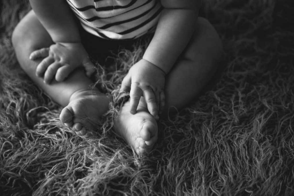 Baby milestone session feet and hands in black and white picture