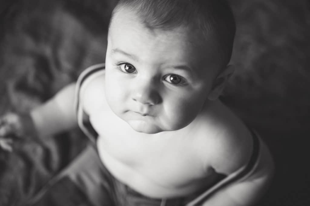 Baby boy in black and white photo looking at camera