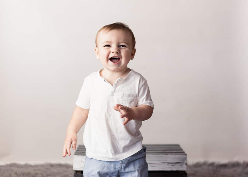 Baby boys first birthday session smiling at the camera