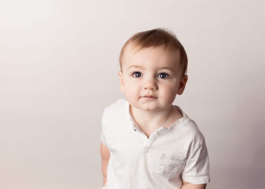 Baby boy on first birthday in a white shirt
