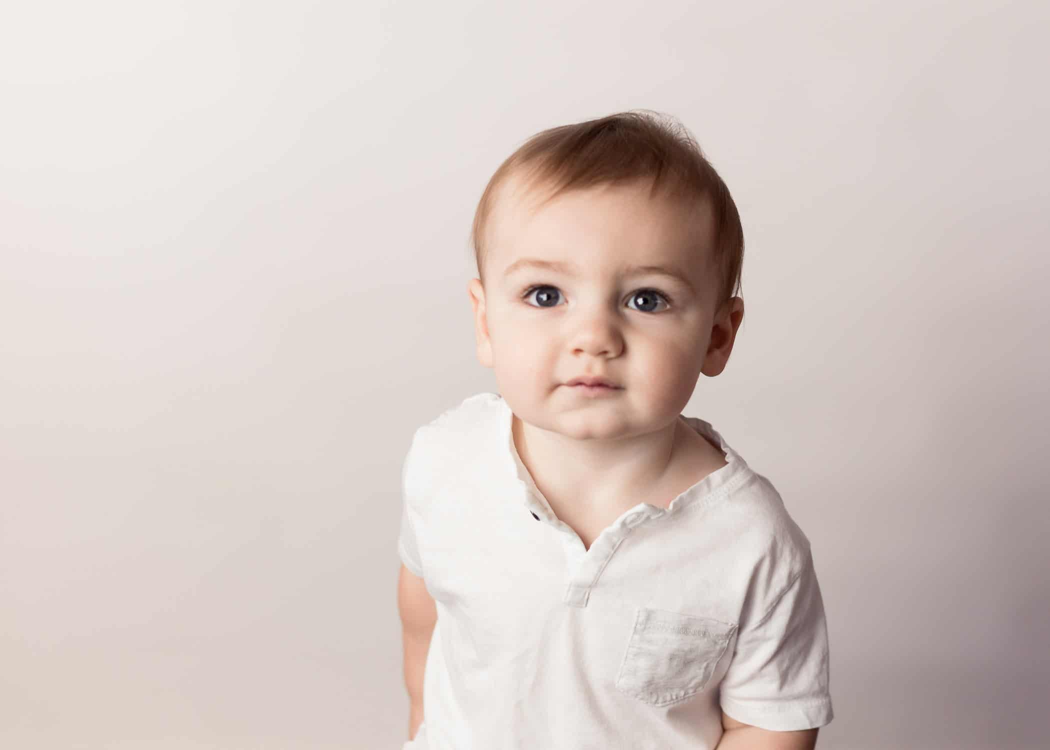 Baby boy on first birthday in a white shirt